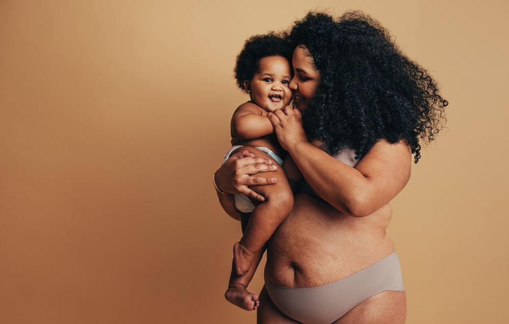 une mère affichant fièrement son corps avec bébé dans les bras